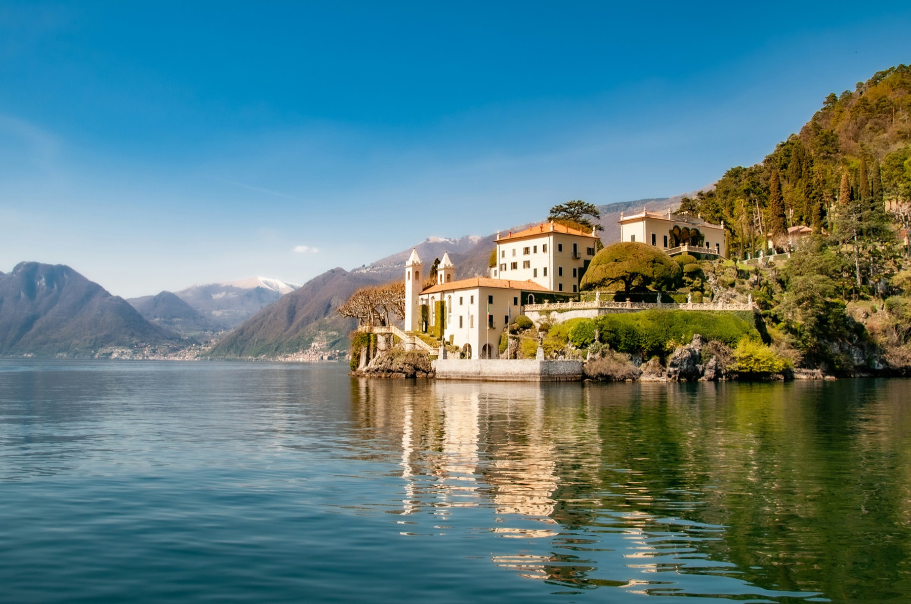 Fachada neoclásica de una villa del siglo XVIII frente al Lago di Como al atardecer, jardines en terraza